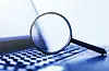 Laptop computer with magnifying glass, concept of search