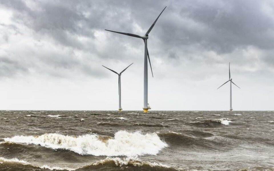 Frågor och svar om havsbaserad vindkraft Wind turbines in an offshore wind park during a storm with big waves hitting the shore.