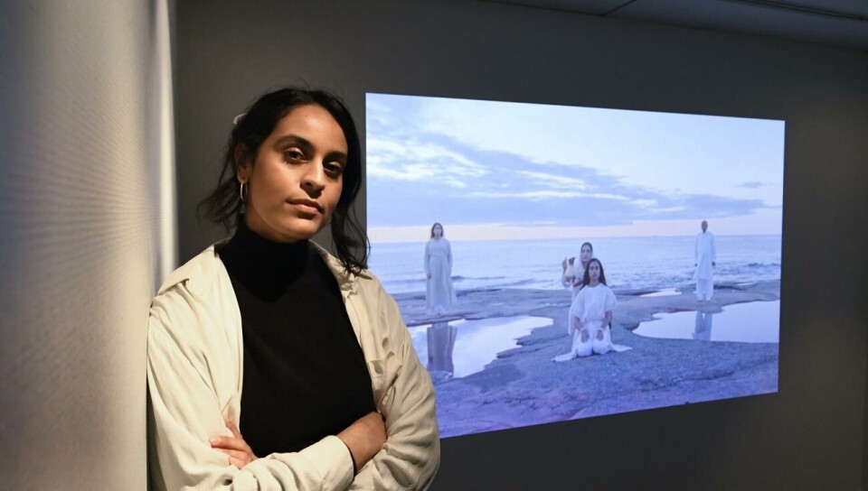 I Nayab Ikrams videokonstverk tvättar hennes mamma hennes hår under rituella former. I Nayab Ikrams videokonstverk tvättar hennes mamma hennes hår under rituella former. I bakgrunden står hennes pappa och syster.Robert Janson