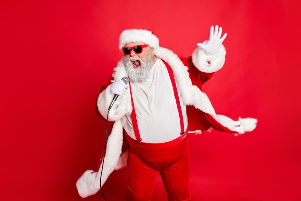 Julmusik hör till den här tiden på året och drar i gång stämningen inför storhelgerna. Nöje har lyssnat på årets nya släpp och ger blandade betyg. Portrait of cool funny fat overweight santa claus with big belly sing song on christmas party wear style stylish trendy eyeglasses eyewear, hat isolated over red background