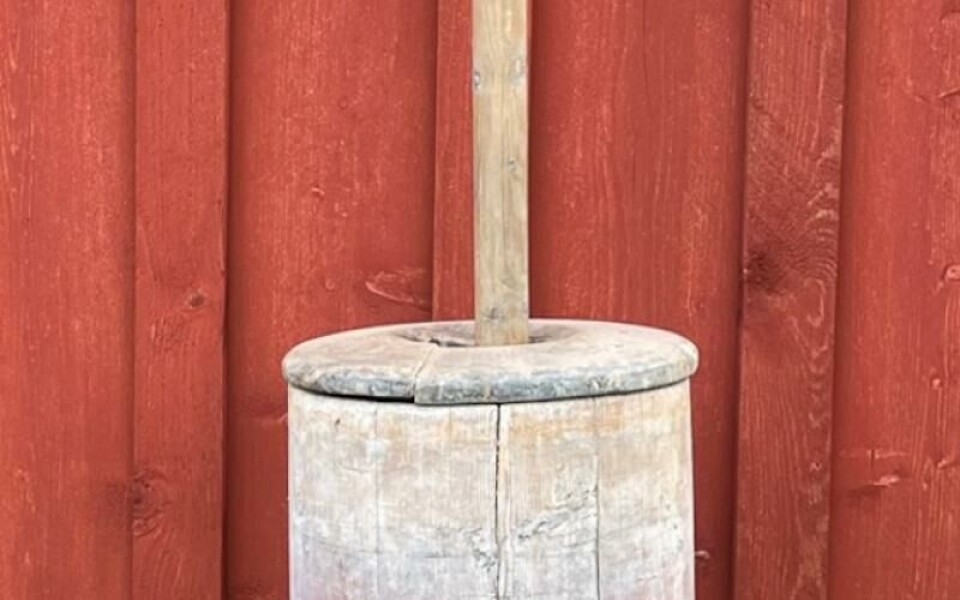 Smörkärna och kärnvipp. Konstruktionen fästes i stugtaket och hävstångstekniken gjorde kärningen lättare. Observera att kärnstaven har ett järnbeslag upptill som användes till att fästa den i vippen. Foto: