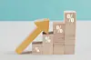 Wooden blocks with percentage sign and arrow up, financial growth, interest rate increase, inflation concept