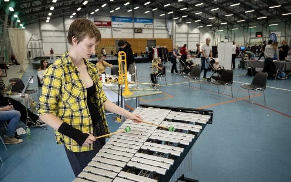 Sara Engström från ungdomsorkesterns styrelse visar hur man spelar på en vibrafon. Foto: DANIEL ERIKSSON