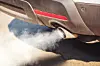 air pollution from dirty and aged vehicle exhaust pipe on road