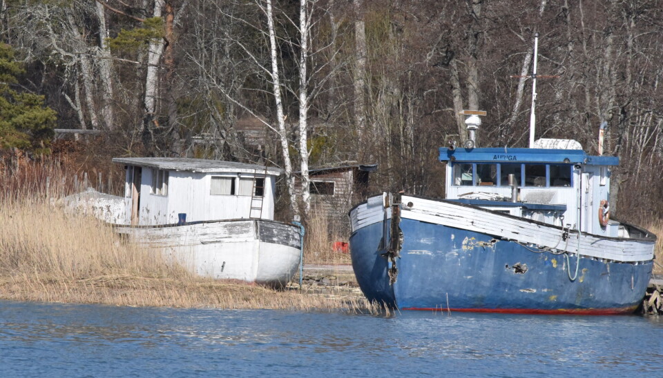 Trålbåten till höger är övergiven och markägaren anser inte att det är hans sak att tömma den på olja och bränsle.