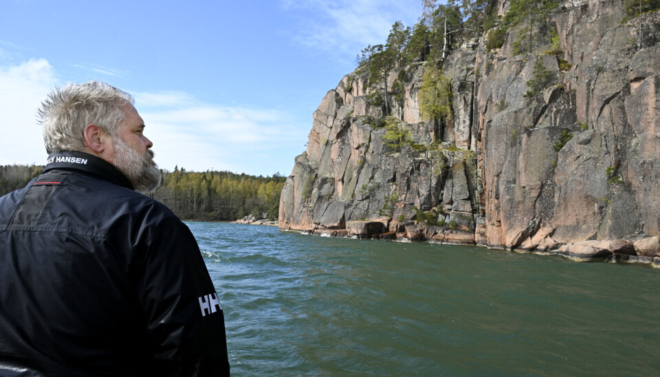 Vindstilla dagar speglar sig berget i vattnet. Här stannar Henrik Mattsson båten, så att gästerna kan lyssna på Ålands museums audioguide.