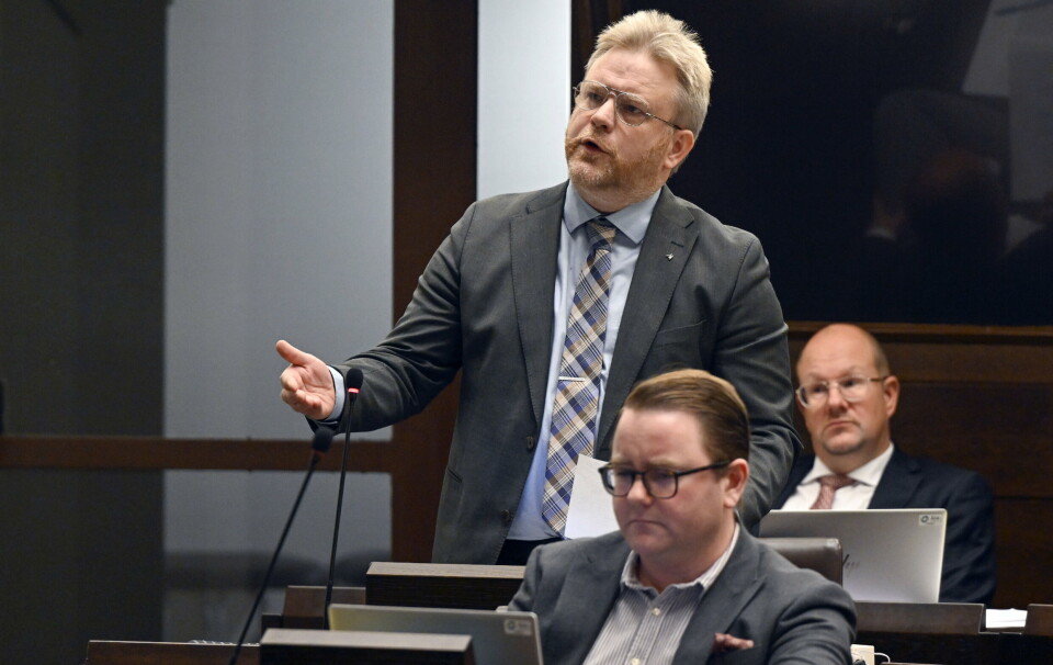 Wille Valve (MSÅ) (stående) och Alfons Röblom (HI) (i förgrunden) fattar beslut om misstroende efter att ha hört landskapsregeringens svar. I bakgrunden syns Anders Holmberg (MSÅ).